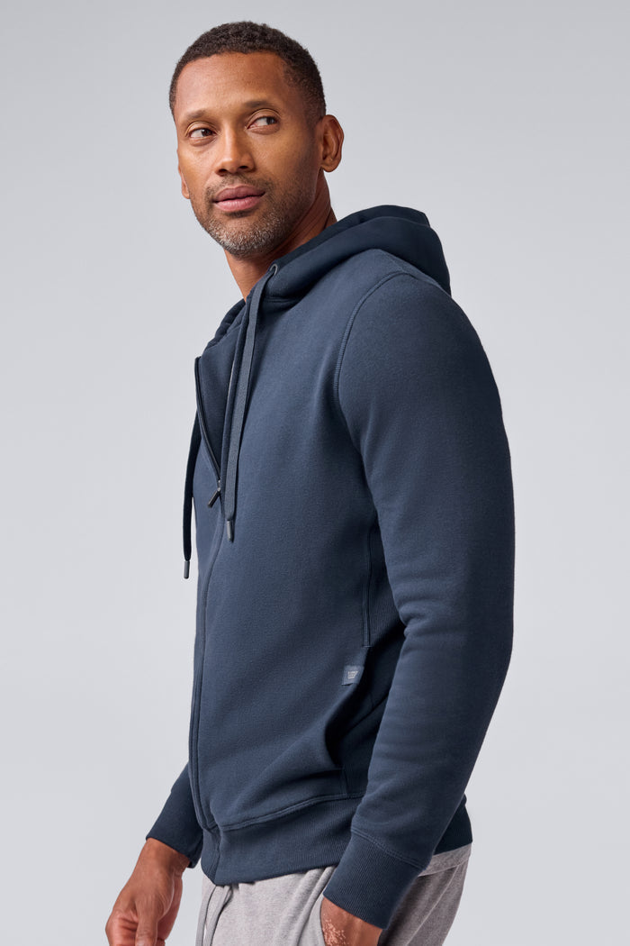 Side view of a man wearing ACE Full-Zip Hooded Sweatshirt in Total Eclipse Blue