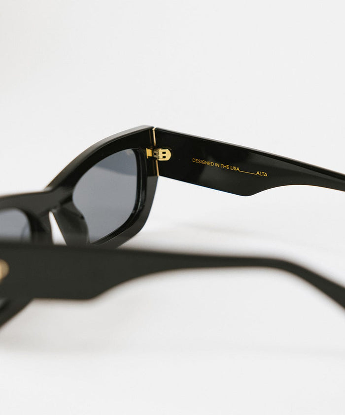 Close up image of black sunglasses on a plain background #color_black