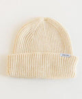An oatmeal colored knit beanie with the brand label on a white background #color_oatmeal