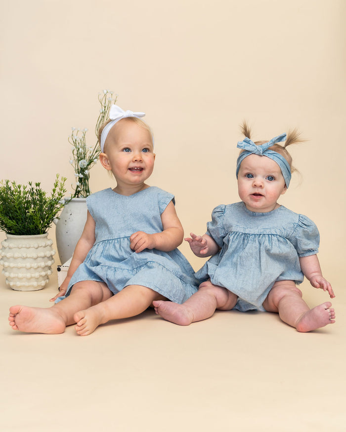 Models wearing River Soft Denim Dress (Left) and Aspen Soft Denim Washed Baby Romper (Right)
