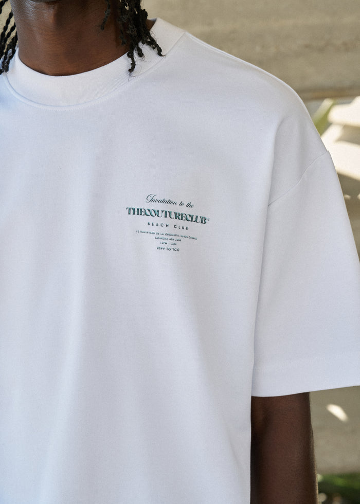 White t-shirt with text on a person wearing it featuring a blurred background