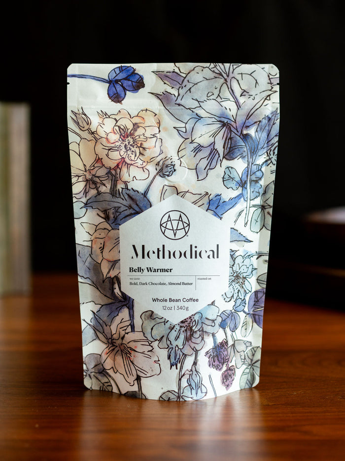 Belly Warmer whole bean coffee bag by Methodical Coffee with bold floral pattern.
