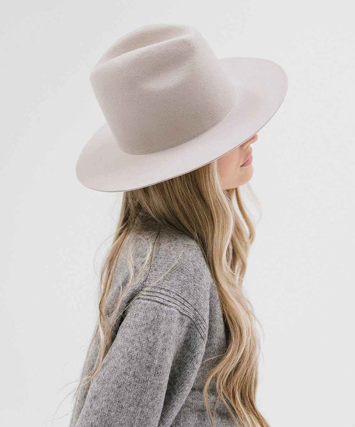 Person wearing an ivory colored hat and grey sweater, facing sideways against a white background #color_ivory