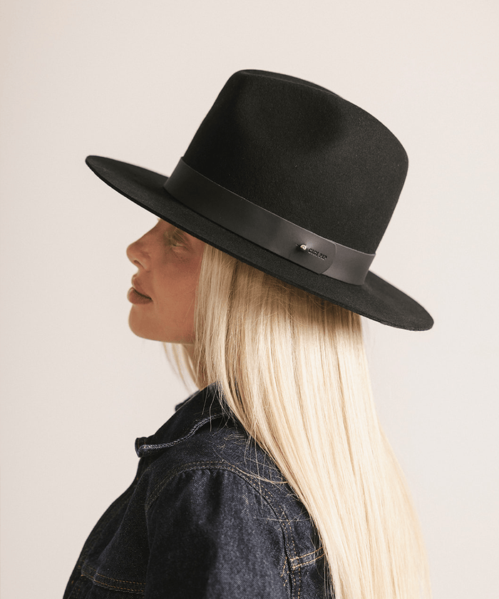 Woman wearing a black tall fedora hat against a plain background #color_black