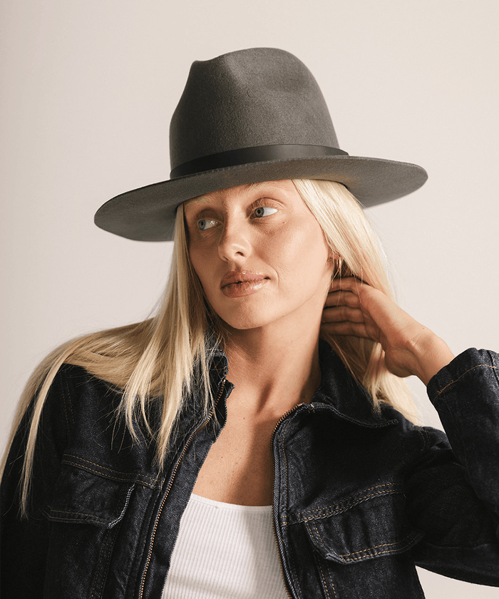 Woman wearing a grey fedora hat on a white background #color_dark grey