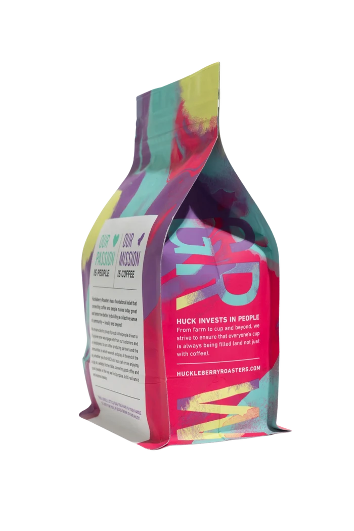 Back view of the Blue Orchid Blend coffee bag displaying product details amid colorful packaging