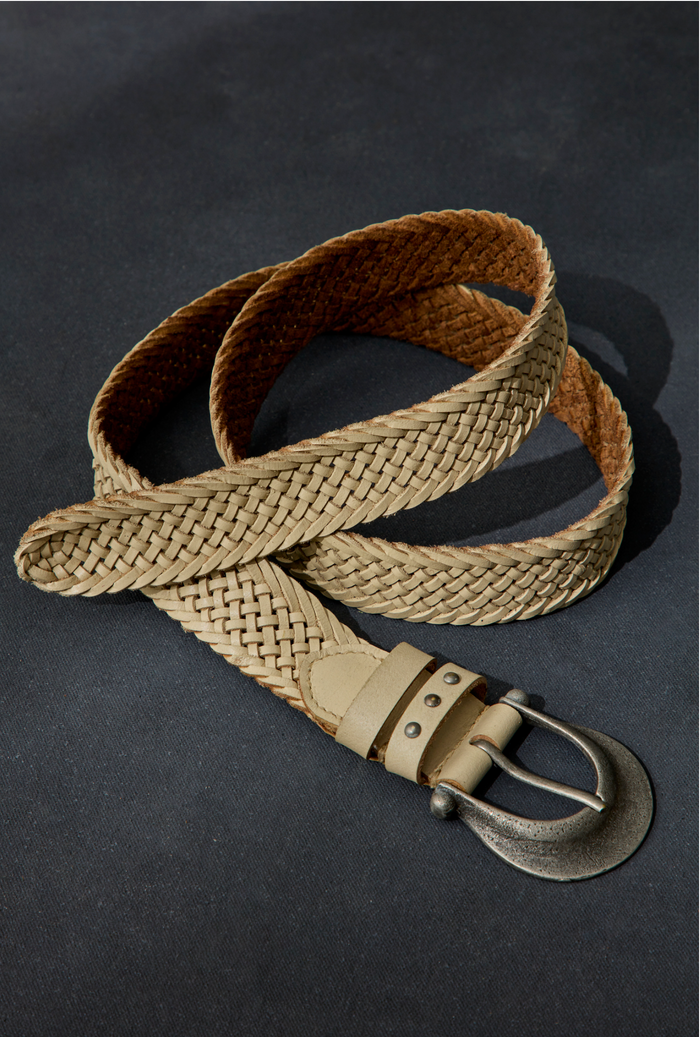 A medium width khaki leather belt with a chunky Western buckle and a woven design.
