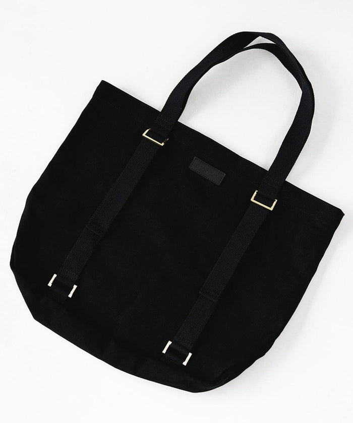 A black canvas tote bag on a plain background with two adjustable straps designed to carry a hat  #color_black