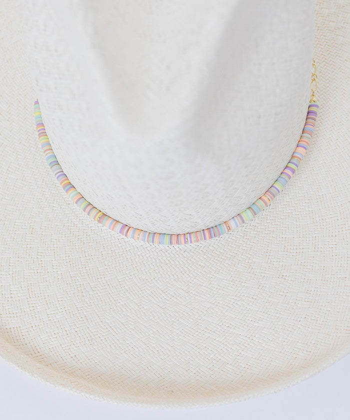A white hat with a multi colored beaded hat band against a plain background #color_multi