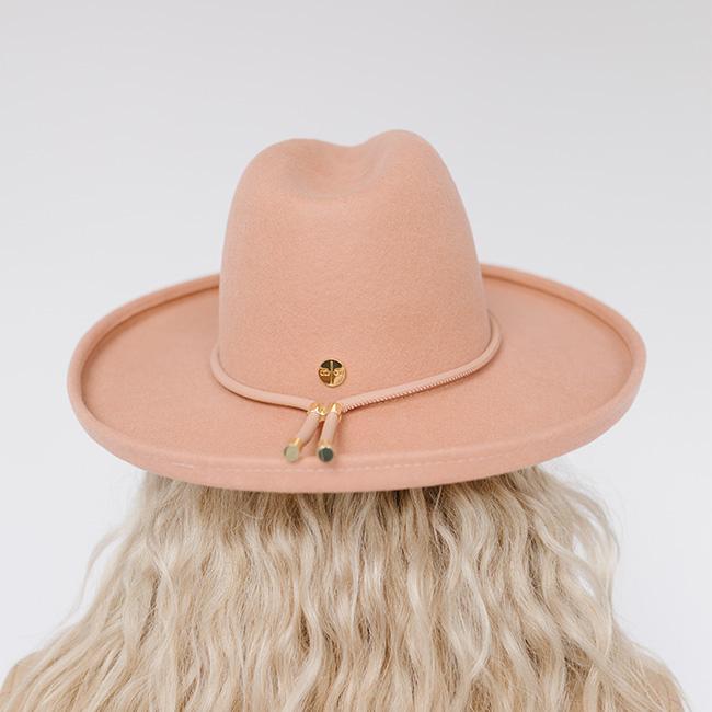 Person wearing a dusty pink pencil brim fedora hat with a hat band, facing behind against a plain background  #color_dusty pink
