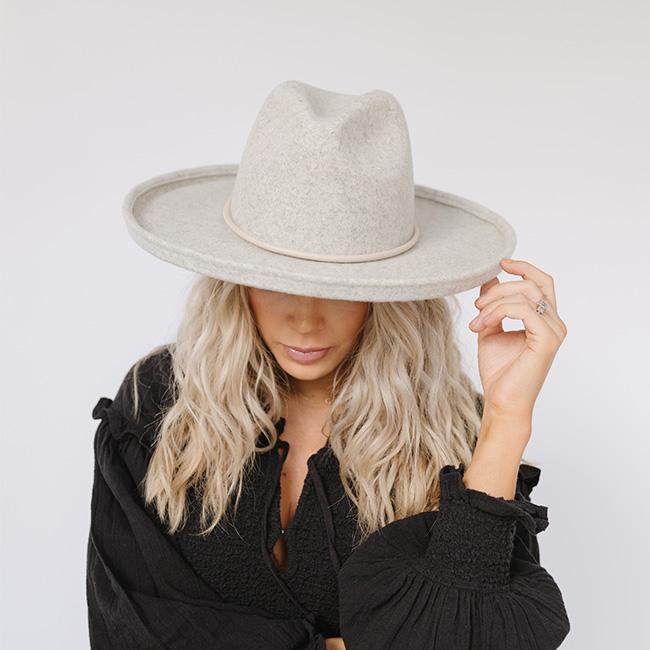 Woman wearing a heather grey pencil brim fedora hat and a black top against a plain background  #color_heather grey
