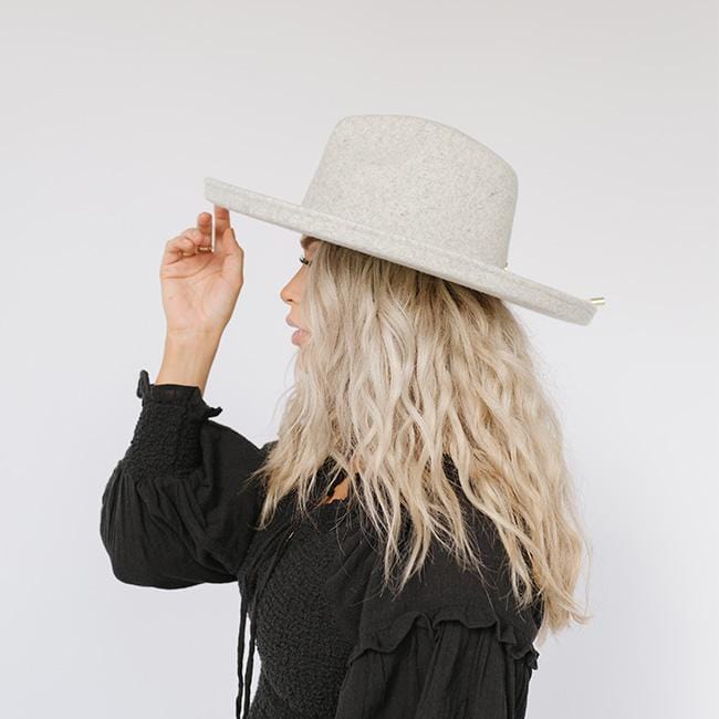 Woman wearing a heather grey pencil brim fedora hat and a black top, facing sideways against a plain background  #color_heather grey