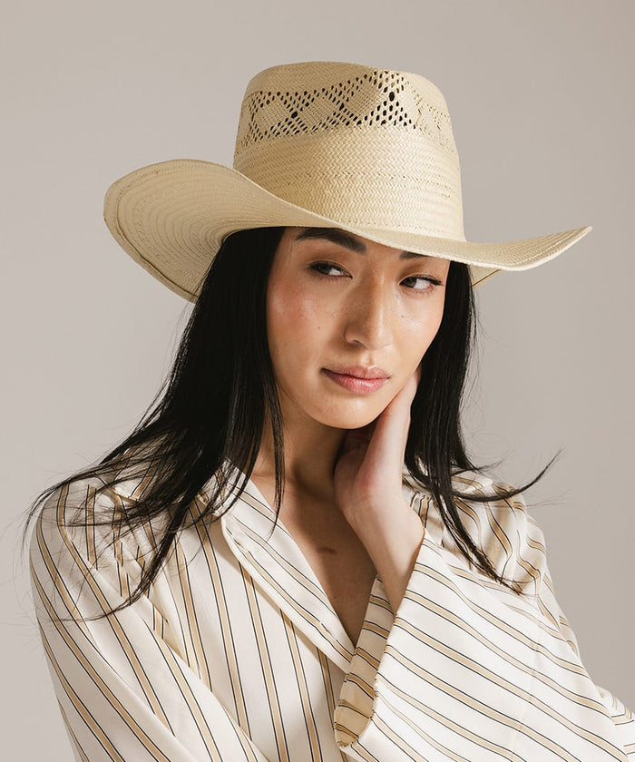 Woman wearing a cowboy hat on a neutral backgound #color_natural
