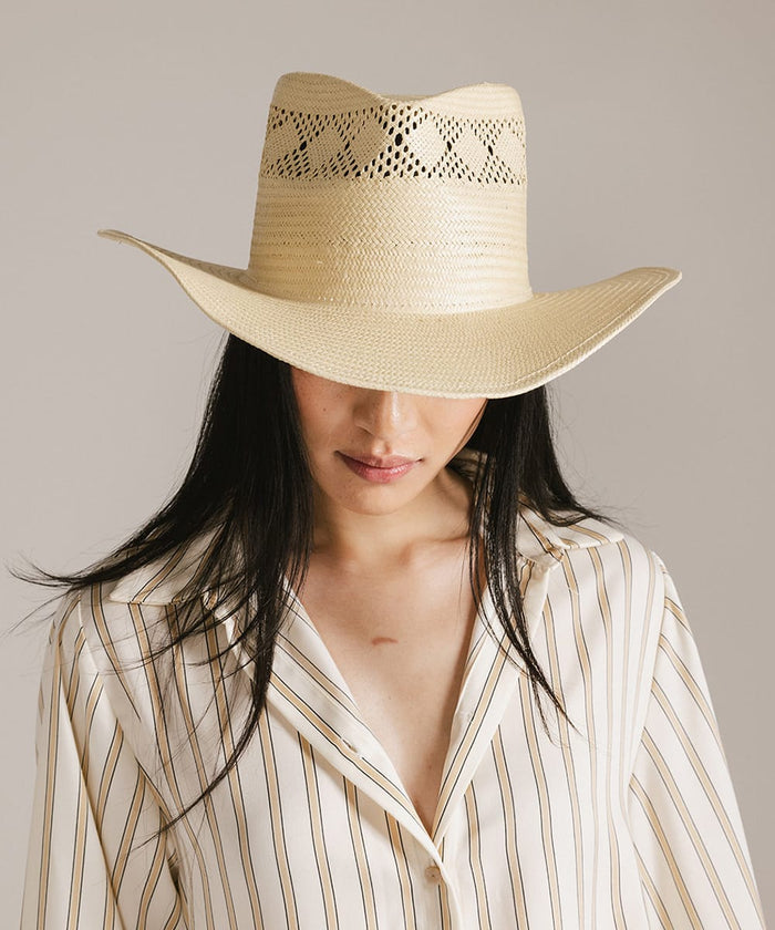 Woman wearing a beige cowboy hat against a neutral background #color_natural