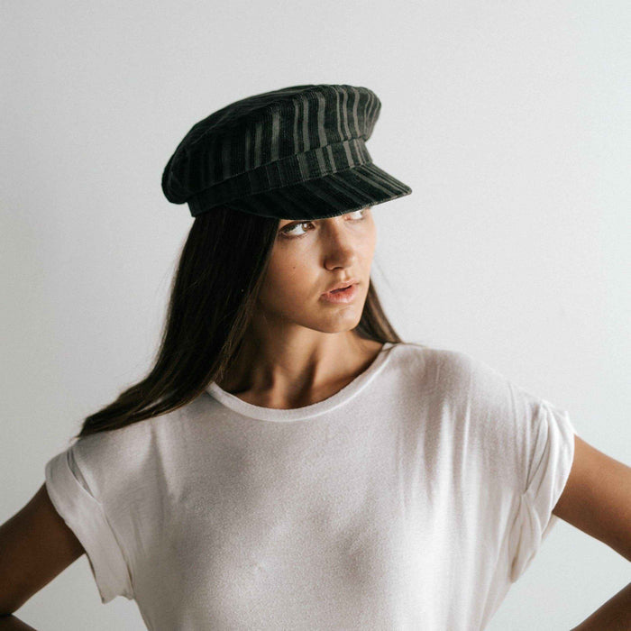 Woman wearing a forest green colored striped cap and a white t-shirt against a plain background  #color_forest green