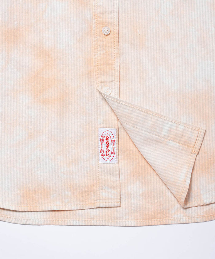 Gramicci peach Bleach Stripe colored Classic Oxford Bleached Shirt hem detail against a light-tone background.