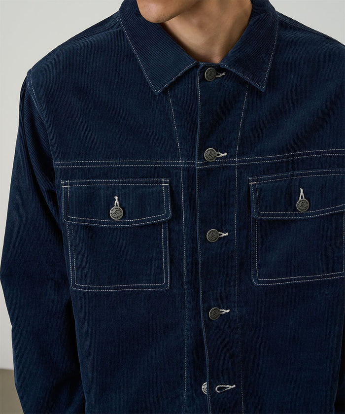 Model wearing a Gramicci Navy Corduroy Trucker Jacket against a light-tone background.