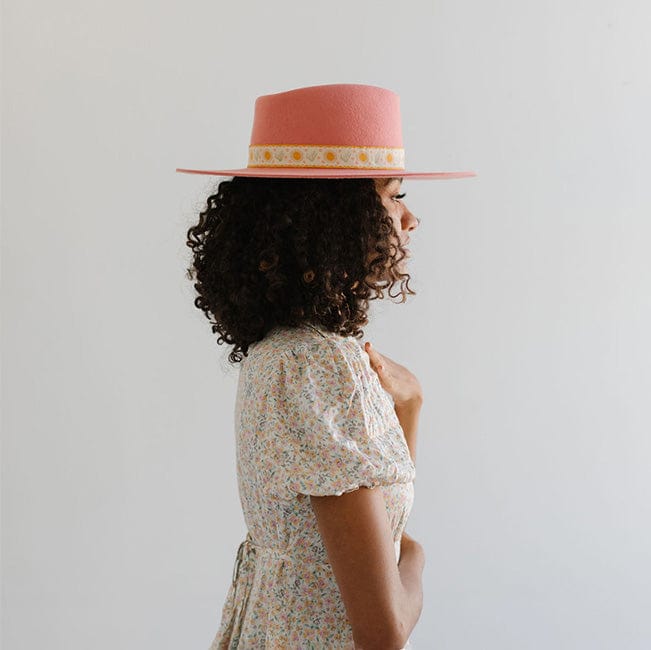 Woman wearing a pink Dakota Dae Triangle Crown hat with a band and a light colored top, facing sideways against a plain background #color_pink