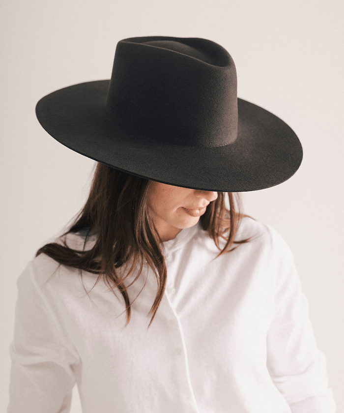 Woman wearing a wide brim felt hat on a white background #color_dark brown