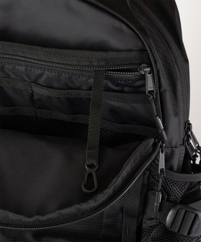 Close-up of Gramicci Day Pack 25L backpack interior in the color black against a light-tone background.