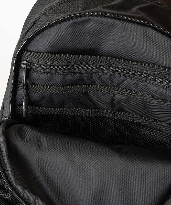 Close-up of Gramicci Day Pack 25L backpack interior in the color black against a light-tone background.