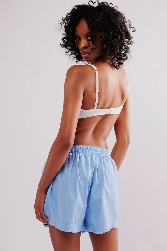 A person wearing a placid blue high-rise boxer shorts with an elastic waistband and a logo tag detail, back view