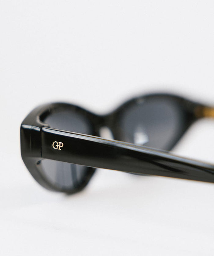 Side angle of a black colored cat eye sunglasses on a white background #color_black