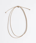 A tan double strand rope hat band on a plain background #color_tan