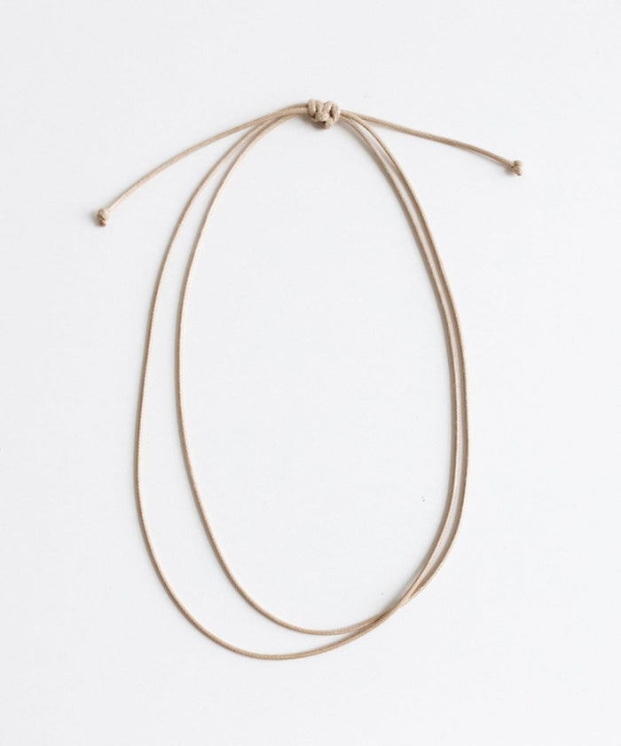 A tan double strand rope hat band on a plain background #color_tan