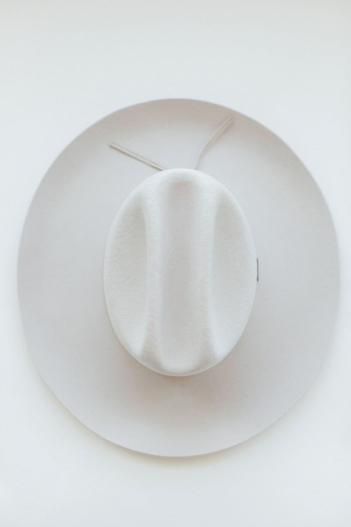 An ivory colored cowboy hat on a white background #color_ivory