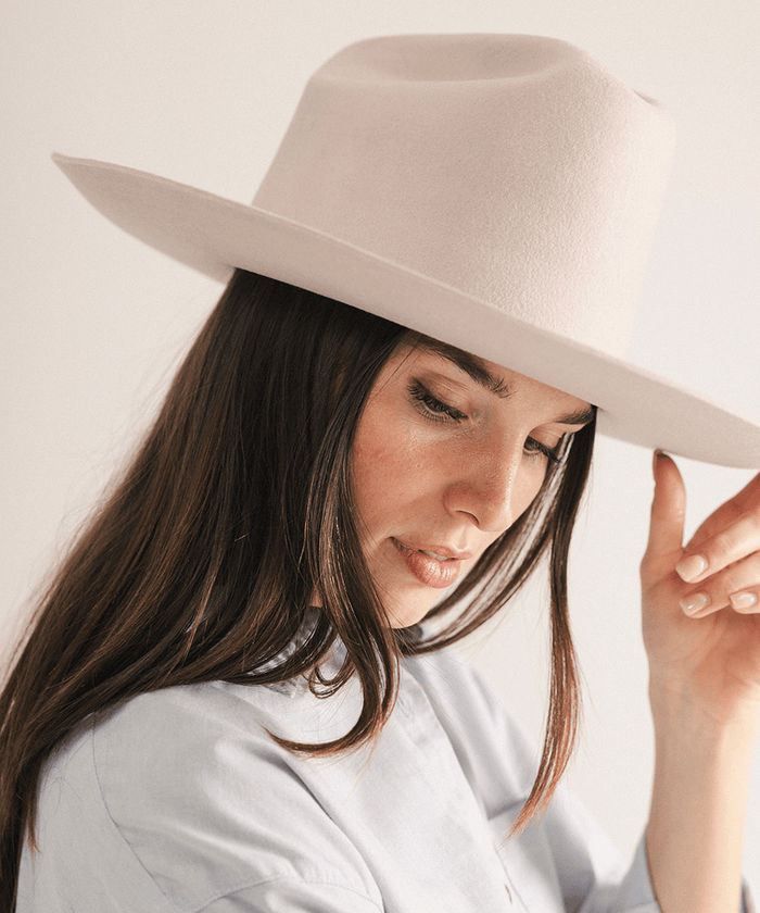 Woman wearing a western felt hat on a white background #color_ivory
