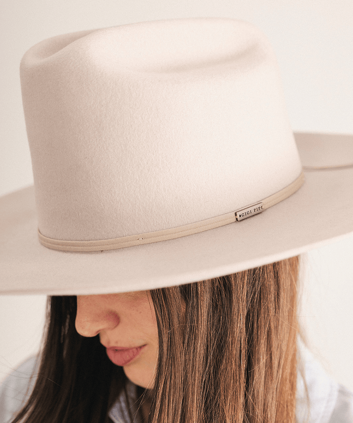 Woman wearing a western felt hat on a white background #color_ivory