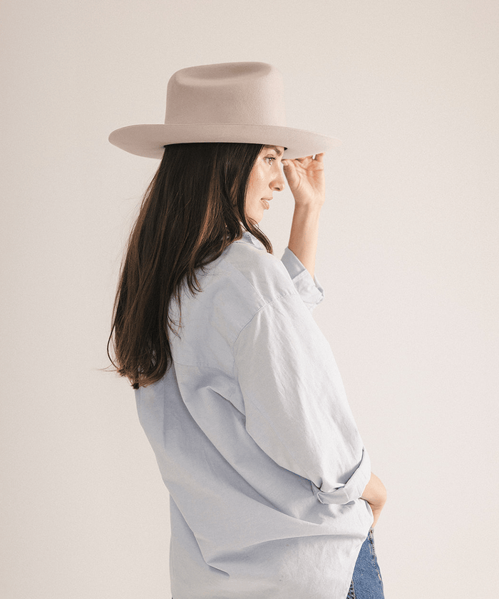 Woman wearing a western felt hat on a white background #color_ivory
