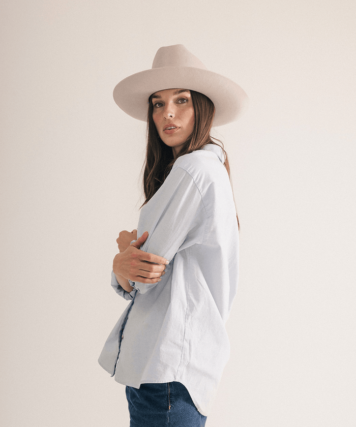 Woman wearing a western felt hat on a white background #color_ivory