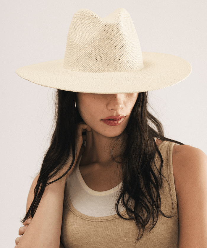 Woman wearing a beige straw hat on a plain background #color_natural