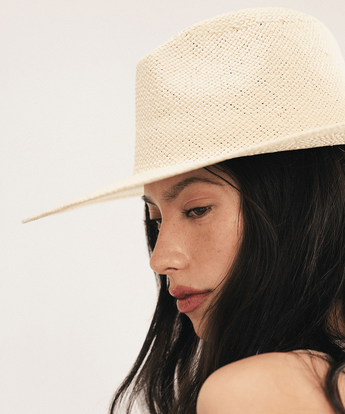 Woman wearing a beige straw hat on a plain background #color_natural