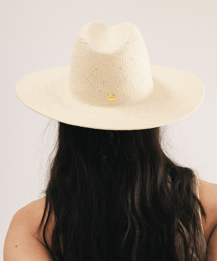 Woman wearing a beige straw hat on a plain background #color_natural