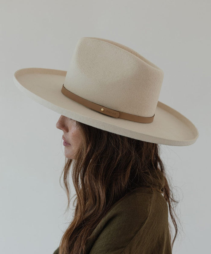 Woman wearing a cream hat with a tan genuine leather thin hat band facing sideways against a plain background #color_tan