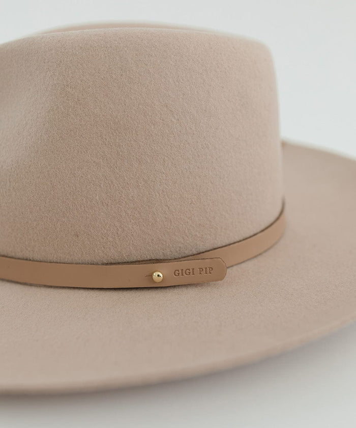 Close up image of a cream hat with a tan genuine leather thin hat band with the brand label against a plain background #color_tan