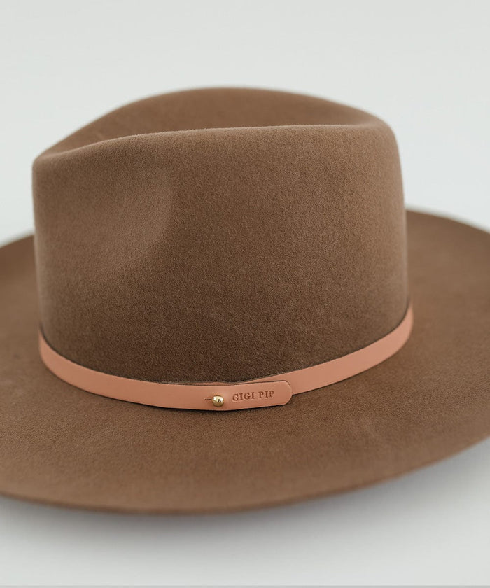 Close up image of a brown hat with a sunset colored genuine leather thin hat band with the brand label against a plain background #color_sunset
