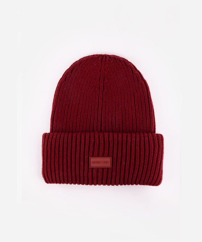 Burgundy knit beanie with a small patch on a white background #color_burgundy