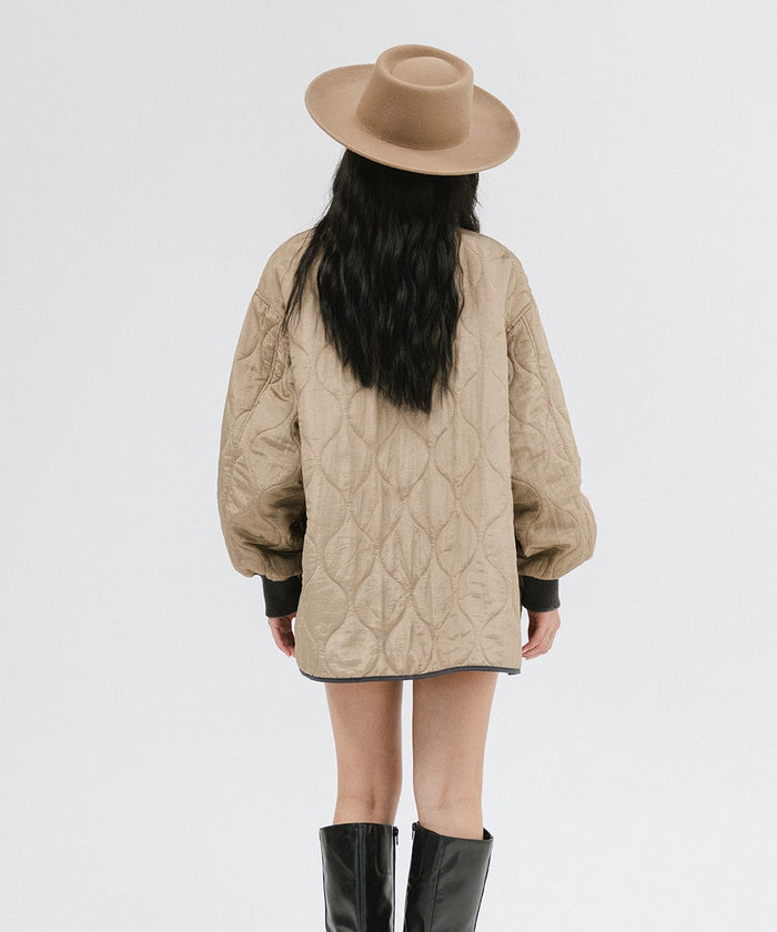 Woman wearing a brown gambler hat, a black top with a brown jacket, and black boots, facing behind against a plain background #color_brown