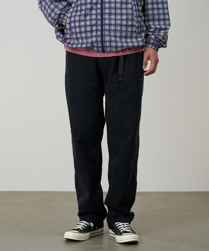 Model wearing black Gramicci Pants and a blue checkered jacket on a light-tone background.