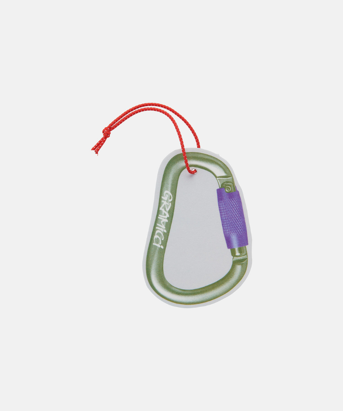 Olive Gramicci & retaW Carabiner Car Tag air freshener against a light-tone background.