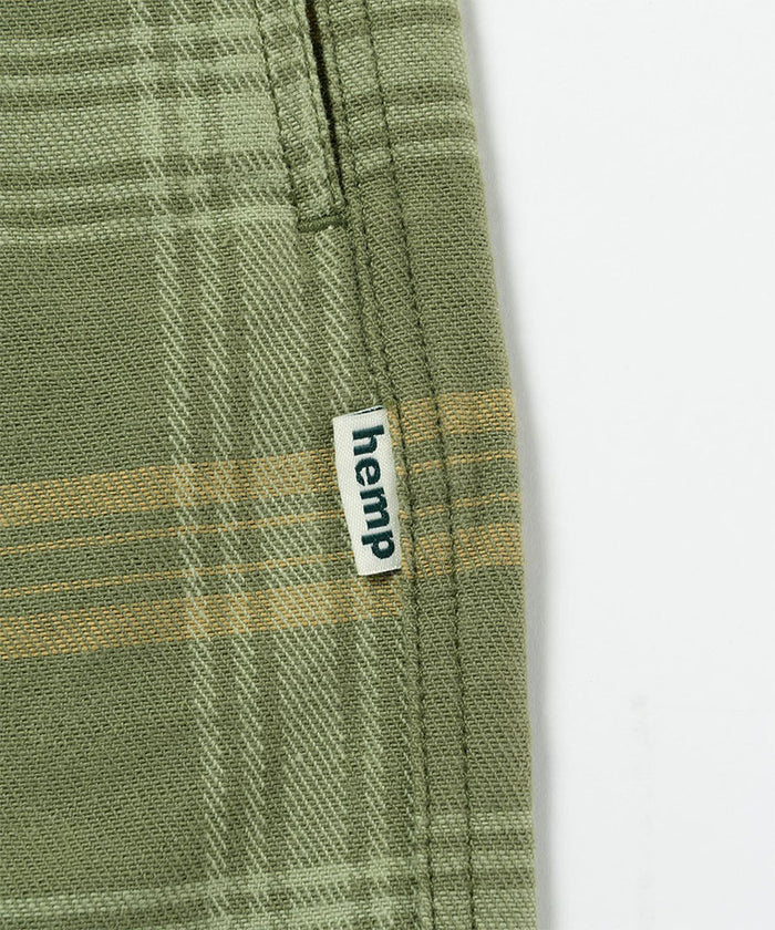 Close-up view of olive plaid Gramicci Hemp G-Short Plaid on a light-tone background.