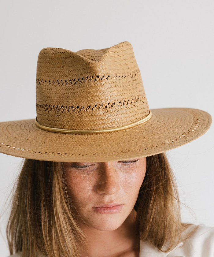 Woman wearing a brown hat with a gold chain hat band against a plain background #color_gold