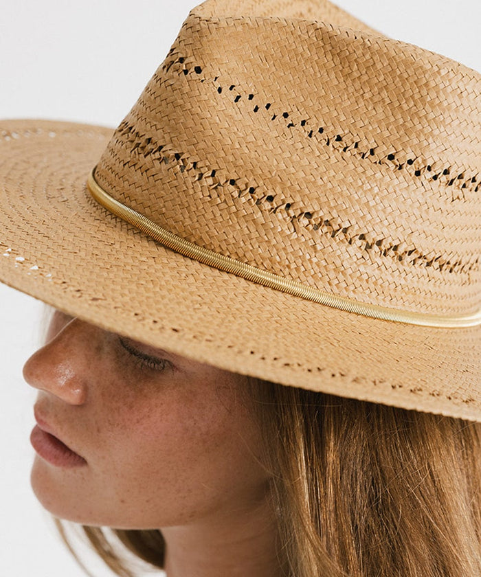 Close up image of a woman wearing a brown hat with a gold chain hat band against a plain background #color_gold