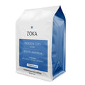 Zoka Hidden City blend coffee bag with white top and blue label listing South America notes
