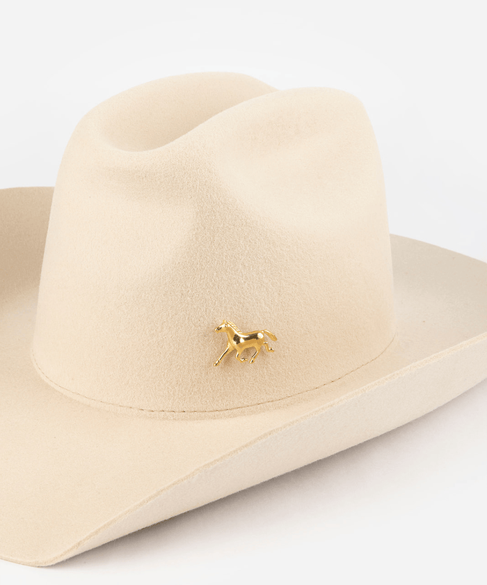 Pink cowboy hat with a gold horse hat pin on a white background #color_gold