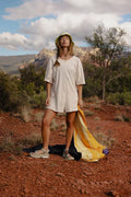 Woman wearing Free People Hot Shot Tee Romper Coddy in bleached clay standing in outdoors